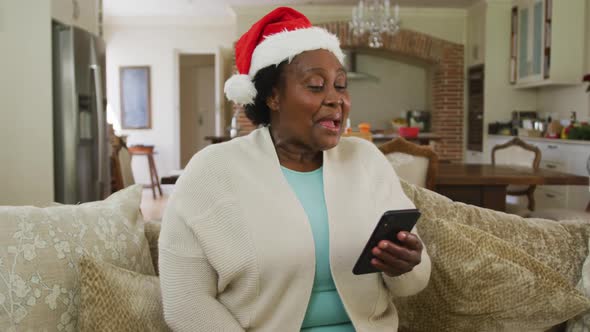 Happy senior african american woman wearing santa hat at chrsitmas time