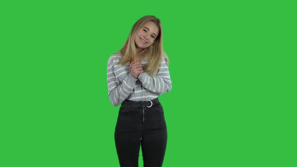 Blonde Girl with Long Hair Is Clapping Her Hands with Joy on Green Screen