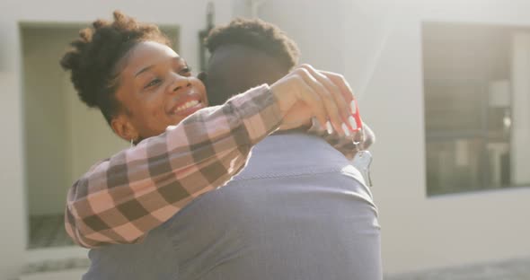 Video of happy african american couple embracing and showing keys to new house