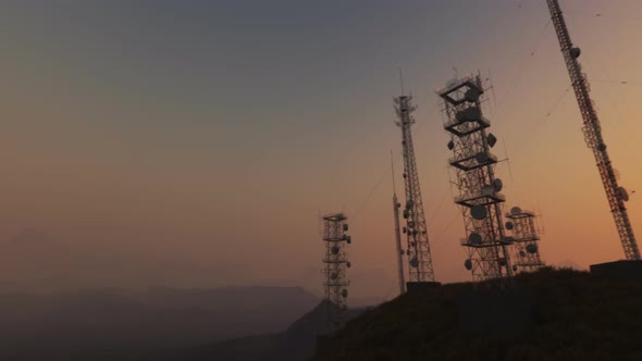 Antenna complex on a hill flythrough. Tall masts or towers during sunset.