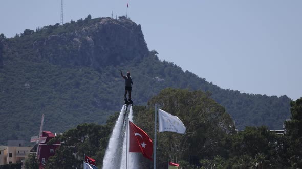 A Man on a Flyboard Entertains Vacationing Tourists on the Turkish Coast in Kemer