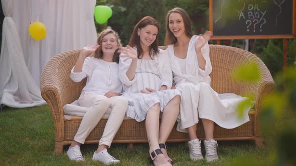 Joyful Smiling Pregnant Woman Young Daughter and Teenage Girl Sitting on Couch on Backyard Waving