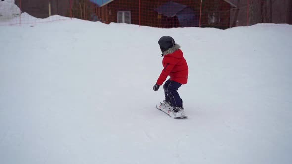 Young Man Snowboard Instructor Tiches Little Boy How To Ride a Snowboard. Winter Activities Concept