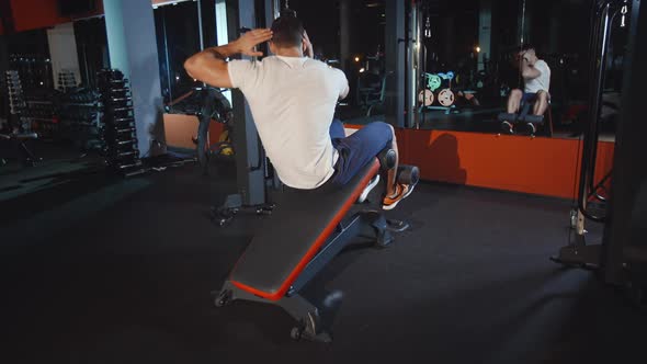 Muscular Athlete Do Abdomen Muscles Workout Exercise on Training Apparatus in Gym