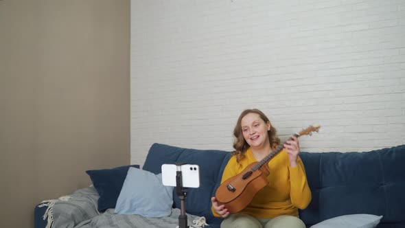 Woman Conducts an Online Lesson and Teaches Students to Play the Ukulele