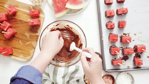 Step by step. Dipping watermelon cubes into melted chocolate and garnishing with sea salt and almond