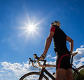 Road cyclist resting on his bike. Backlight, sunny summer day. - PhotoDune Item for Sale