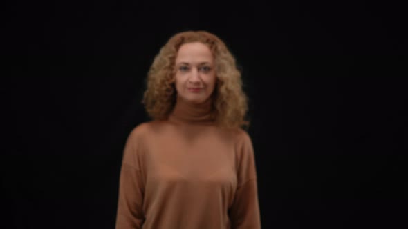 Confident Caucasian Woman Walking in Camera Flashes at Black Background Smiling