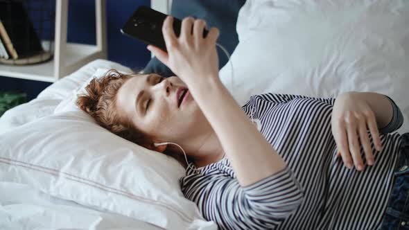 Video of redhead woman having a video conference via phone