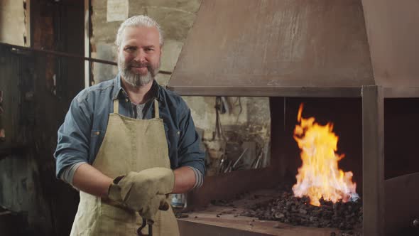 Portrait of Cheerful Blacksmith by Forge