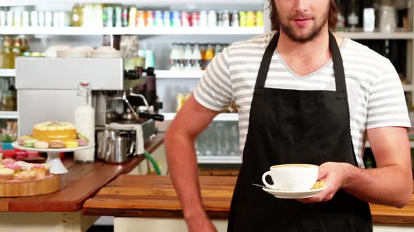 Male waiter holding a cup of coffee