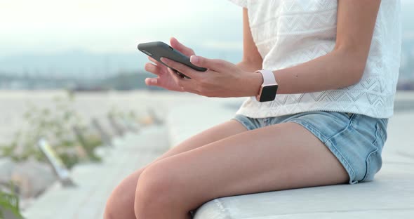 Close up of woman using mobile phone in city