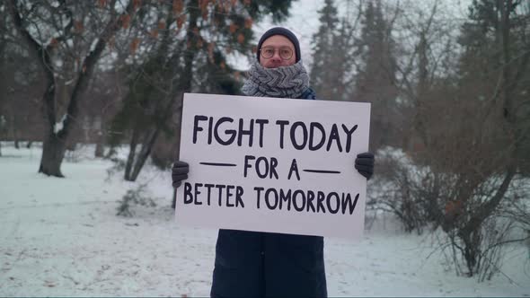 A male protester is holding a huge banner Fight today for better tomorrow