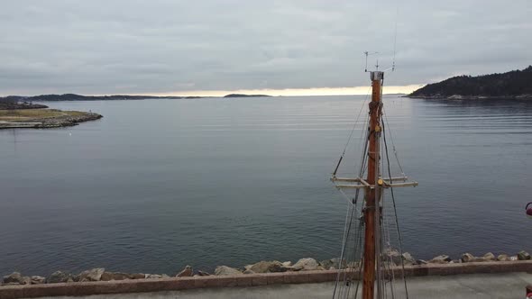 Aerial passing close to wooden sailing boat mast with north sea and horizon in background - Aerial f