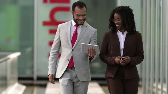 Smiling Lawyers Looking at Tablet During Stroll