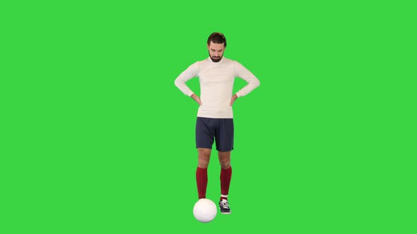 Football Player Walking Slowly and Kicking the Ball on a Green Screen Chroma Key