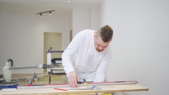 Carpenter Makes Measurements and Draws on Wood