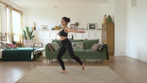 A young Indian Female Ballerina trains at home, Does a Spinning exercise, Bright Cozy Room