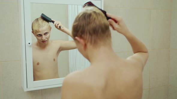 Handsome Man Looking Face In Front Of Mirror. Sexy Manat Bathroom Comb Hair