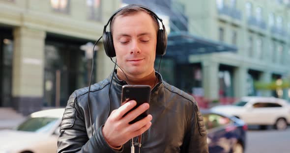 Man Wearing Headphones in a City