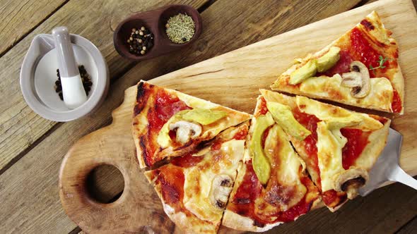 Delicious pizza with ingredients on wooden table