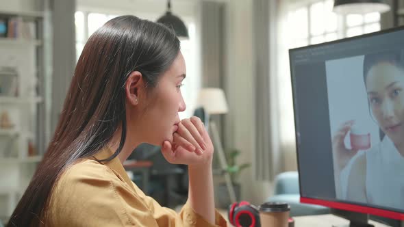 Asian Female Digital Editor Thinking While Works In Photo Editing Software On Her Personal Computer