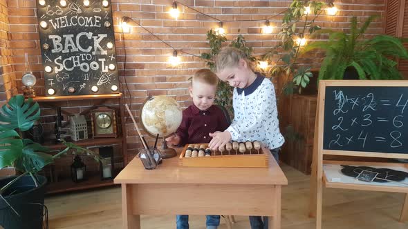 Schoolchildren - a girl and a boy are studying abacus in the classroom