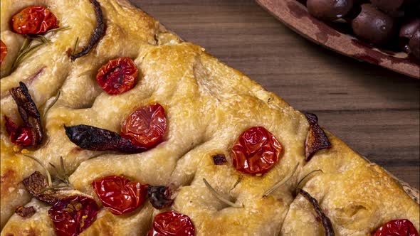 Traditional Italian Focaccia with cherry tomatoes, black olives and rosemary.