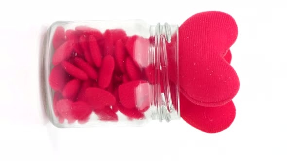 Rotation Small red heart on a clear glass jar isolated on white background, Vertical video format.