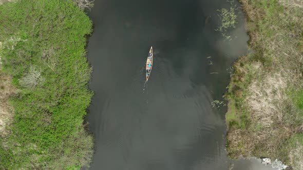 Top down shot of a canoe being paddled through an estuary