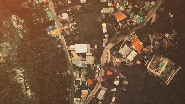 Top Down Aerial Cityscape with Lodges Homes Buildings Roofs and Roads at Green Tropic Forest
