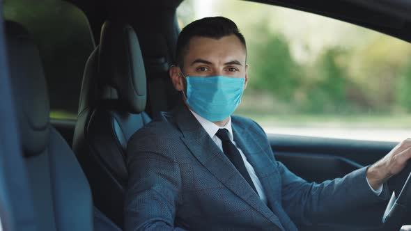 Businessman Wearing Medical Mask in Prevention for Coronavirus and Driving His Car to Work