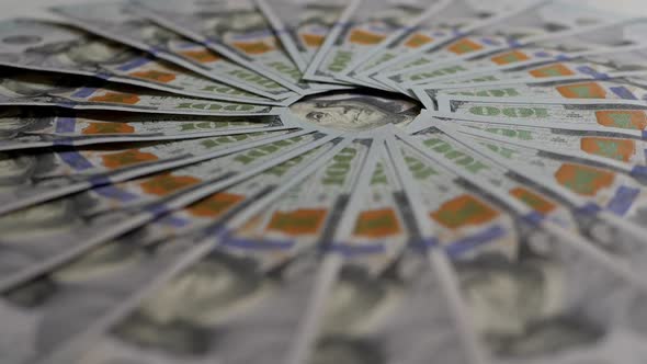 A Closeup of Many Hundreddollar Bills Lie in an Even Circle and Slowly Rotate