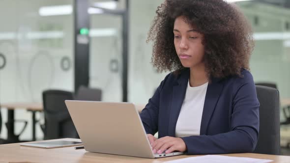 Appreciative Young African Businesswoman with Laptop Doing Thumbs Up