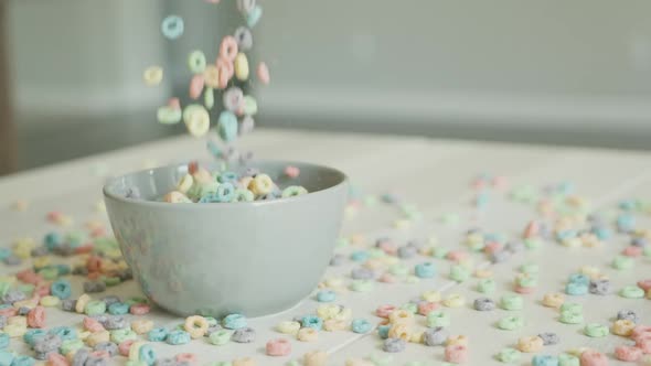 Breakfast Cereals in the Form of Colorful Corn Rings Fall and Fill the Bowl on the Table