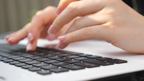 Female Fingers Typing Some Text on Keyboard of Notebook. Unrecognizable Woman Using Laptop Outdoors