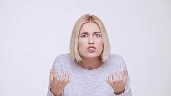 Young Beautiful Shocked Blonde Girl Screaming Over White Background Slow Motion