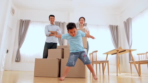 Happy Funny Family And Little Boy Dancing In New House At Moving Day