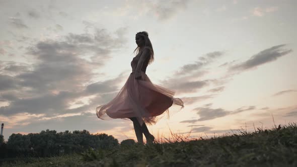 The Girl in the Dress Swirls Magically at Sunset.