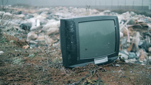 Broken TV with a Garbage Dump in the Background