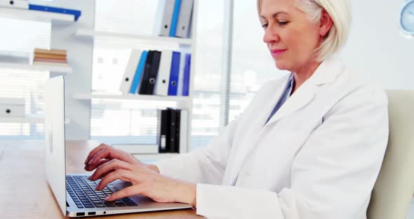 Female doctor working over laptop