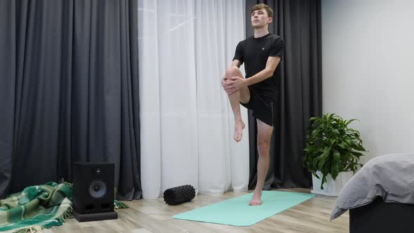 Athletic man does gymnastics exercises on mat.Stretching concept