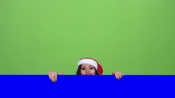 Santa Woman Looks Out of the Blue Board and Shows a Thumbs Up. Green Screen. Slow Motion