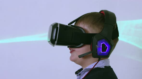 A Boy in Augmented Reality Glasses in Profile Dances and Moves His Arms