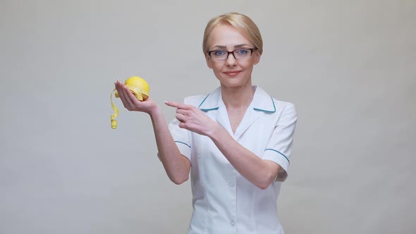 Nutritionist Doctor Healthy Lifestyle Concept - Holding Organic Lemon Fruit and Measurng Tape