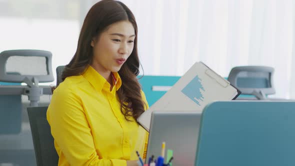 Business Asian woman in yellow shirt meeting Video conference show sale report and explain