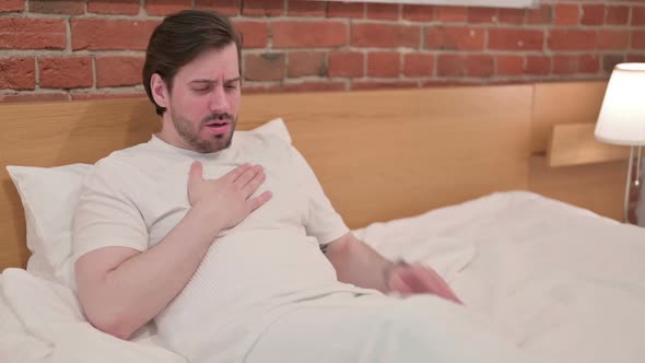 Casual Young Man Crying While Sitting in Bed