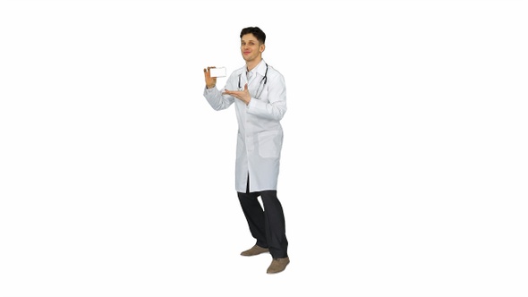 Young doctor presenting new pills and dancing on white background.