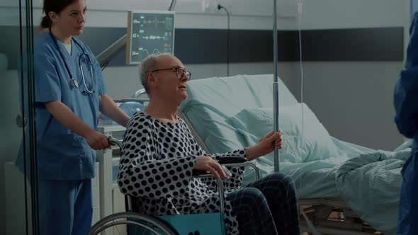 Senior Patient Leaving Hospital Ward in Wheelchair