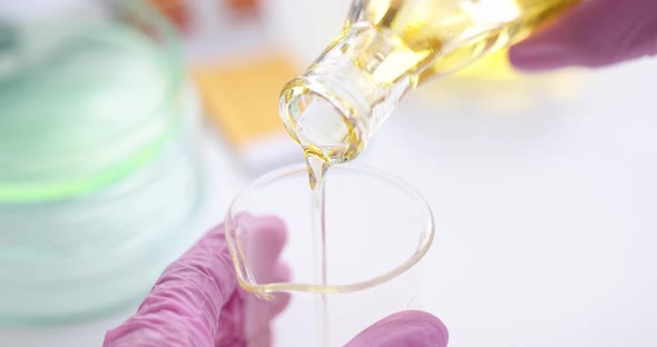 Scientist Chemist Pouring Motor Oil Into Flask in Laboratory Closeup  Movie